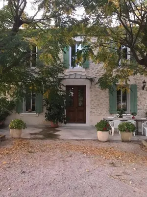 a house with green shutters and a wooden door at Farm House, 10 min d'Avignon in Jonquerettes