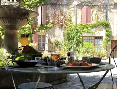 a table with a plate of fruit on it at Auberge du Presbytère in Saignon