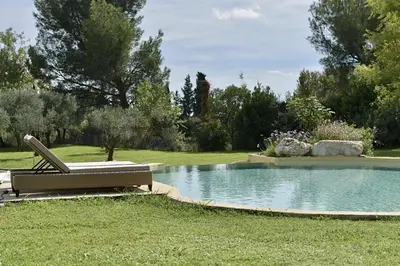 a chair sitting next to a pool in a yard at Maison Satine in Noves