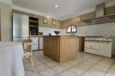 a large kitchen with white appliances and a table at Maison Satine in Noves