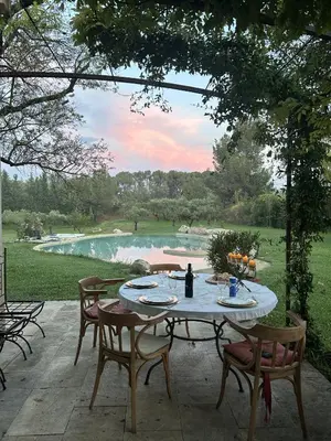 a table on a patio with a view of a pond at Maison Satine in Noves