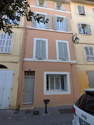 a pink building with white windows and a door at Appartement Aix centre ville in Aix-en-Provence
