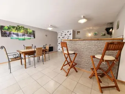a restaurant with a table and chairs and a bar at Gîtes de la Coupière Le Laurier in Aubenas-les-Alpes