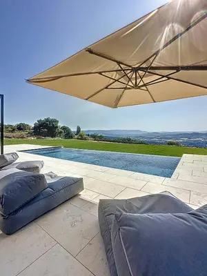 a large tan umbrella sitting next to a swimming pool at 180 Grand Luberon Gordes vue panoramique in Gordes