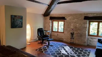 a living room with a chair and a table at Domaine De Pradaous in Reillanne