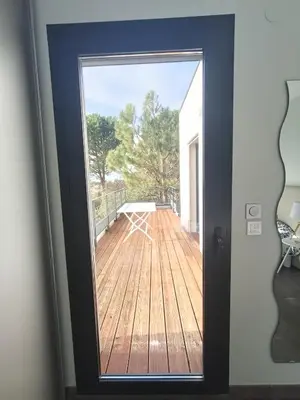 a door with a view of a boat outside at Villa ChloLéa in Caromb