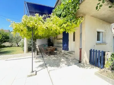 a tree in front of a house with a table at La Treille cozy villa basement in Provence in Sainte-Tulle