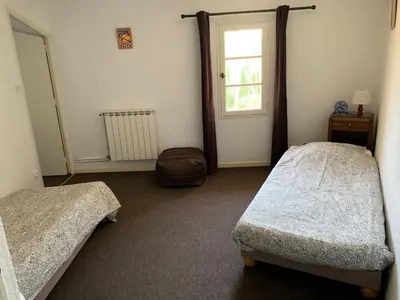 a bedroom with two beds and a window at La Commanderie du Ventoux in Mormoiron