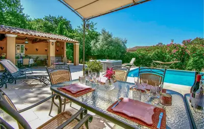 a table and chairs on a patio next to a pool at Maison Avec Piscine Privée in Villars
