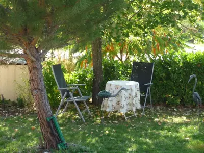 two chairs and a table under a tree at Holiday Home by Interhome in Pierrevert