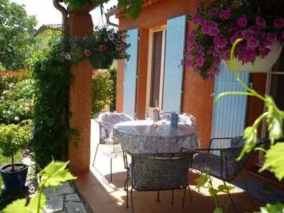 a table and chairs on a patio with flowers at Holiday Home by Interhome in Pierrevert