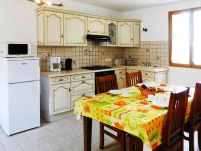 a kitchen with a table and a white refrigerator at Apartment Morard - Bonnieux Appt Les Ocres by Interhome in Bonnieux