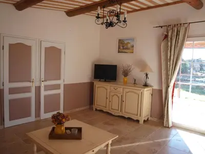 a living room with a tv and a table at Holiday Home Provenzalisches Ferienhaus mit Charme auf dem Land mit Pool by Interhome in Villars