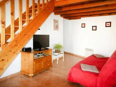 a living room with a red couch and a television at Apartment Morard - Bonnieux Appt 2- Etage by Interhome in Bonnieux
