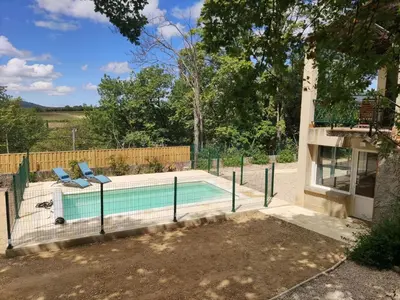 a swimming pool with two chairs next to a house at Holiday Home Villa Roche en Provence Süd Luberon by Interhome in Ansouis