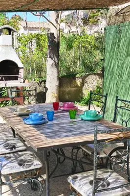 a wooden table with colorful bowls on top of it at Holiday Home Villa Roche en Provence Süd Luberon by Interhome in Ansouis