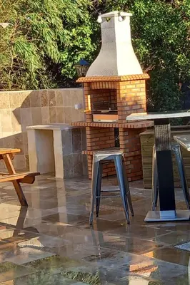 a outdoor kitchen with a table and a brick oven at Apartment Valentins Gîte Moulin de Tartay in Avignon by Interhome in Avignon