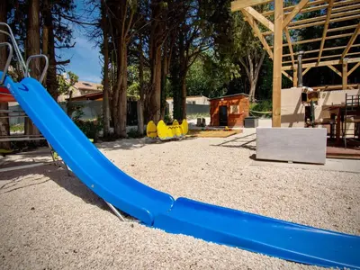 a blue slide in a playground at Apartment Valentins Gîte Moulin de Tartay in Avignon by Interhome in Avignon