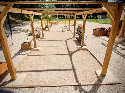 a wooden pergola with a table and some benches at Apartment Leonie's Gîte Moulin de Tartay in Avignon by Interhome in Avignon
