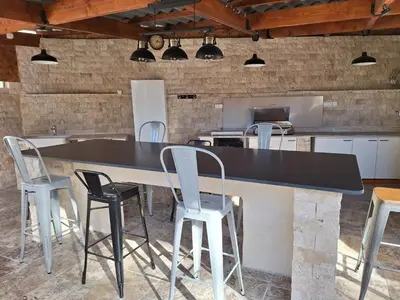 a kitchen with a large black counter and chairs at Holiday Home Moulin de Tartay in Avignon by Interhome in Avignon
