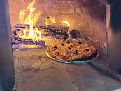 a pizza is being cooked in a brick oven at Holiday Home Moulin de Tartay in Avignon by Interhome in Avignon