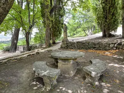 a stone picnic table and benches in a park at Holiday Home Domaine Santonne by Interhome in Apt