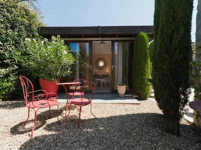a group of chairs and a table in a garden at Holiday Home Das Atelier im Mas Naste by Interhome in Eygalières