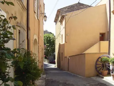 an alley with a building and a wheel next to it at Apartment Morard - Bonnieux Appt Bleu Provence by Interhome in Bonnieux