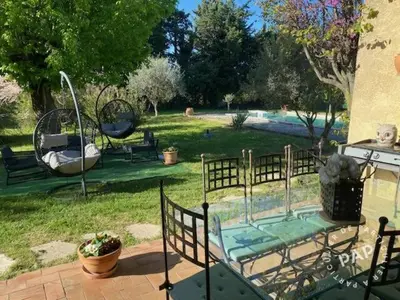 a patio with a fence and a table with a swing at Villa en Provence in Le Thor