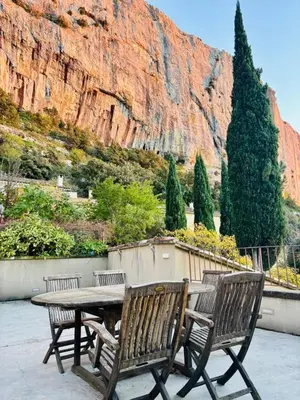 a picnic table with two benches and a mountain at Maison de charme vue sublime et rooftop in Lioux