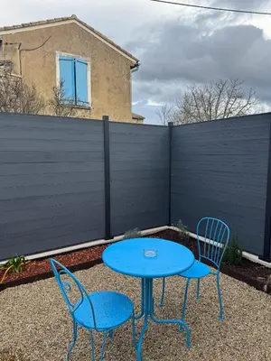 two chairs and a blue table and chairs in a backyard at Esprit Lubéron, Le Romarin, logement entier in Le Thor