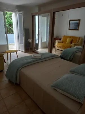 a bedroom with a bed and a living room at Hébergement tout confort au pied du Luberon in Cabrières-dʼAigues