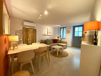 a living room with a table and a couch at L' Ecrevisse in LʼIsle-sur-la-Sorgue