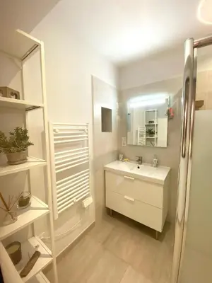 a white bathroom with a sink and a mirror at L' Ecrevisse in LʼIsle-sur-la-Sorgue