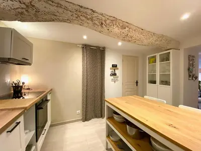 a kitchen with a wooden counter top in a room at L' Ecrevisse in LʼIsle-sur-la-Sorgue