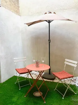 a table with two chairs and an umbrella at L' Ecrevisse in LʼIsle-sur-la-Sorgue