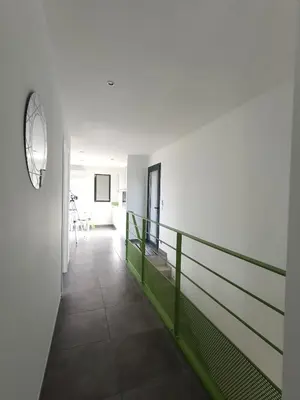 a hallway with a green railing in a building at ChloLéa in Caromb