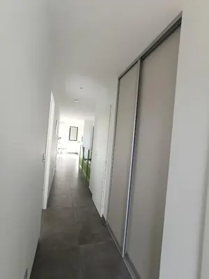 a hallway in an office building with white walls and tile floors at ChloLéa in Caromb