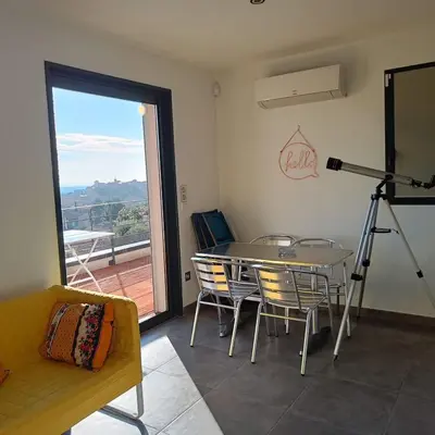 a living room with a table and chairs and a camera at ChloLéa in Caromb
