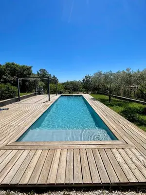 a large swimming pool on a wooden deck at Lourmarin, Maison De Charme Au Coeur Du Luberon in Cadenet
