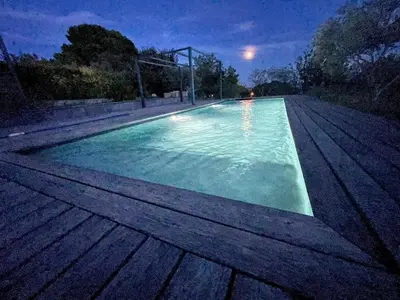 a swimming pool at night with the lights on at Lourmarin, Maison De Charme Au Coeur Du Luberon in Cadenet