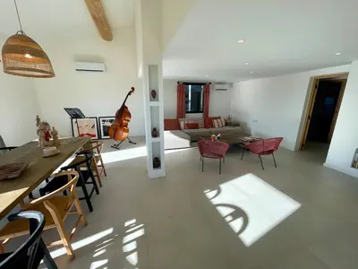 a living room with a couch and a guitar at Lourmarin, Maison De Charme Au Coeur Du Luberon in Cadenet