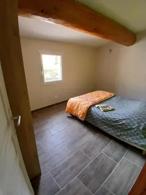 a bedroom with a bed and a wooden floor at Luberon Sud in La Tour-dʼAigues