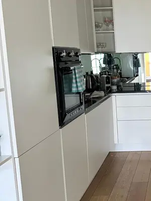 a kitchen with white cabinets and a black oven at Le Pavillon Etoile in Venelles