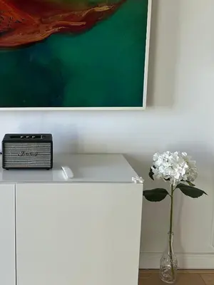 a white counter with a clock and a vase of flowers at Le Pavillon Etoile in Venelles