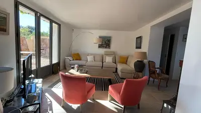 a living room with a couch and a table and chairs at Le Mas des Grillons, mas rénové entièrement climatisé avec piscine et vue Ventoux in Crillon-le-Brave