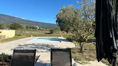 two chairs sitting next to a swimming pool at Le Mas des Grillons, mas rénové entièrement climatisé avec piscine et vue Ventoux in Crillon-le-Brave