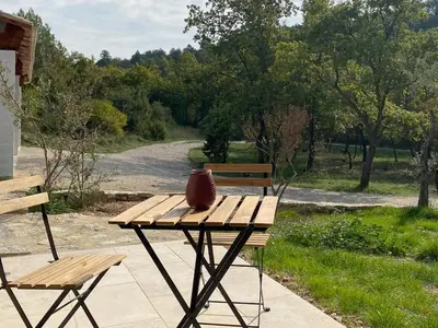 a picnic table with a vase sitting on it next to a bench at LAVANDE in Apt