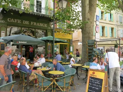 a group of people sitting at tables at an outdoor restaurant at LAVANDE in Apt