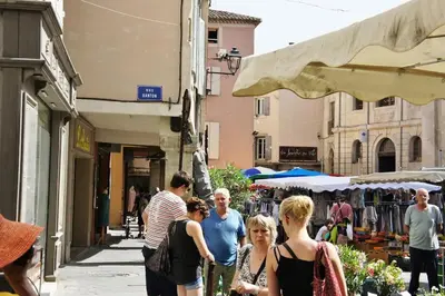a group of people walking down a street at Les Roues de L'Isle - CHARMING APARTMENT in LʼIsle-sur-la-Sorgue
